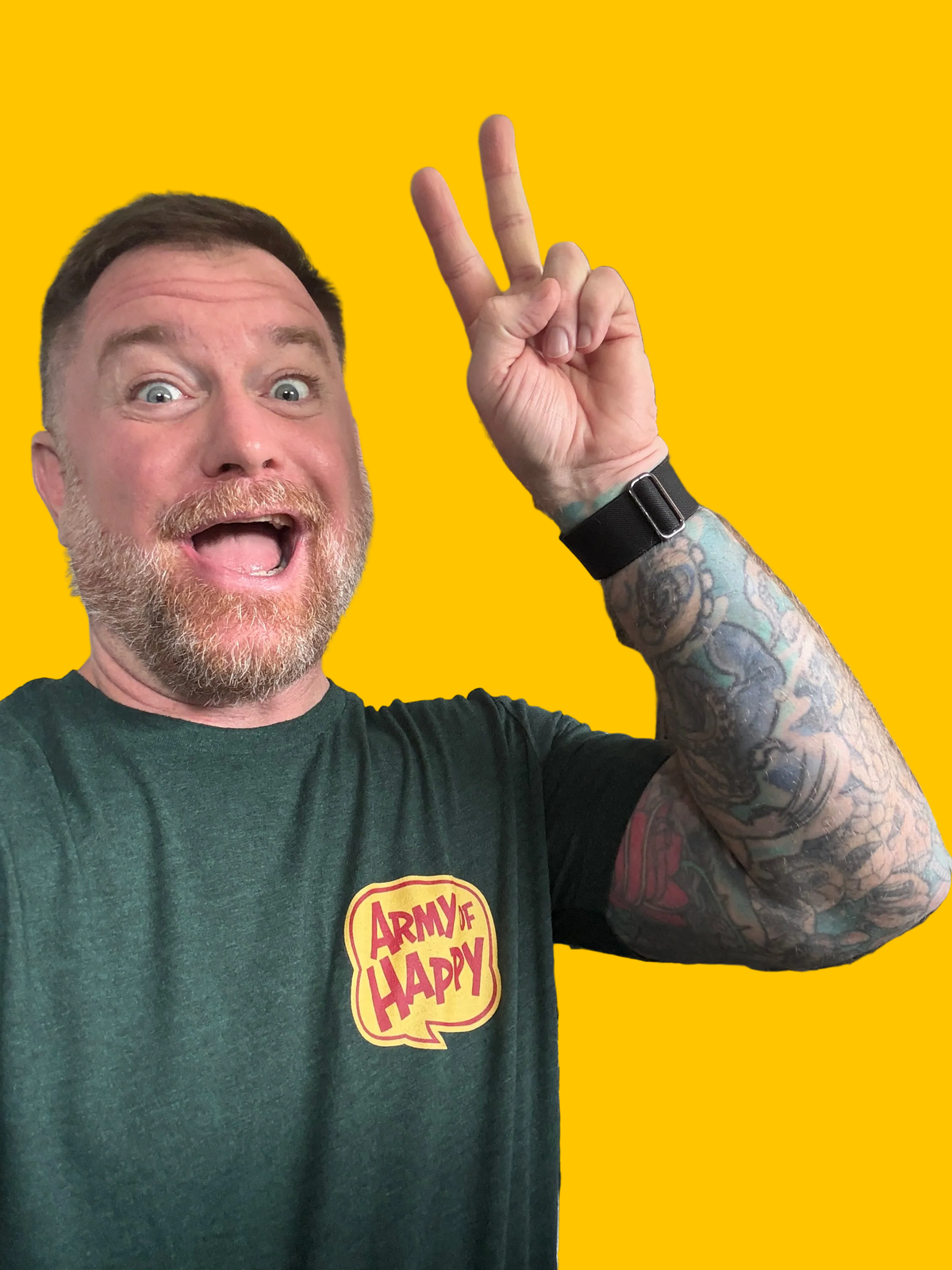 Man making a peace sign with his hand on a yellow background, wearing a green t-shirt with a logo.