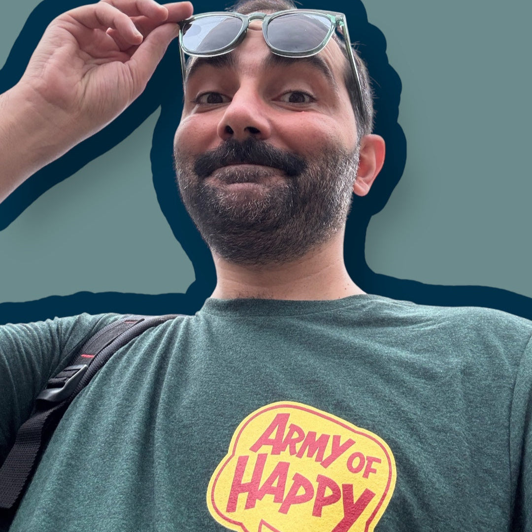 Man wearing a green t-shirt with 'Army of Happy' logo and sunglasses on a blue background
